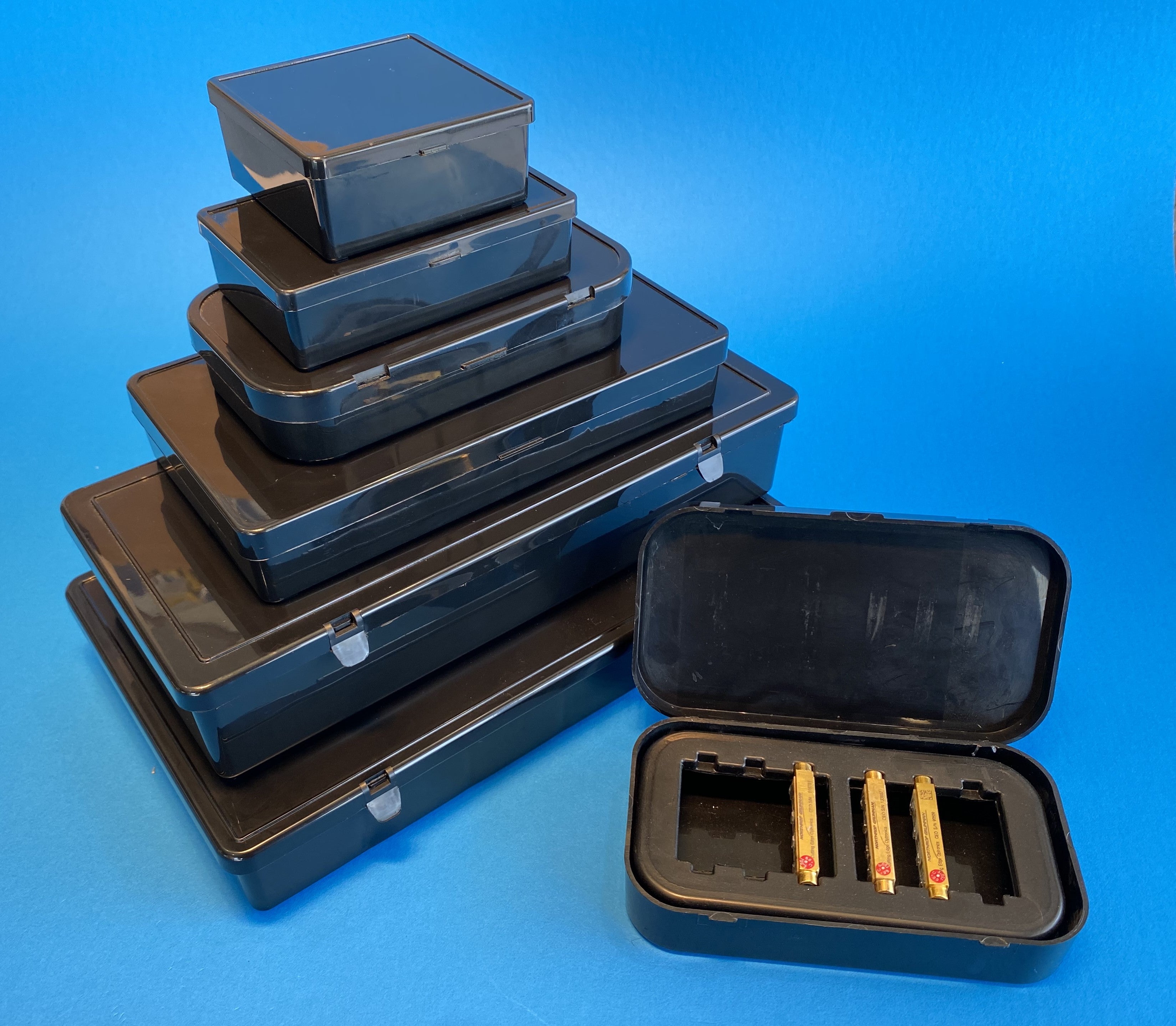 Group of our cases molded in conductive polypropylene ESD-safe including one sample with electronics seated inside an insert